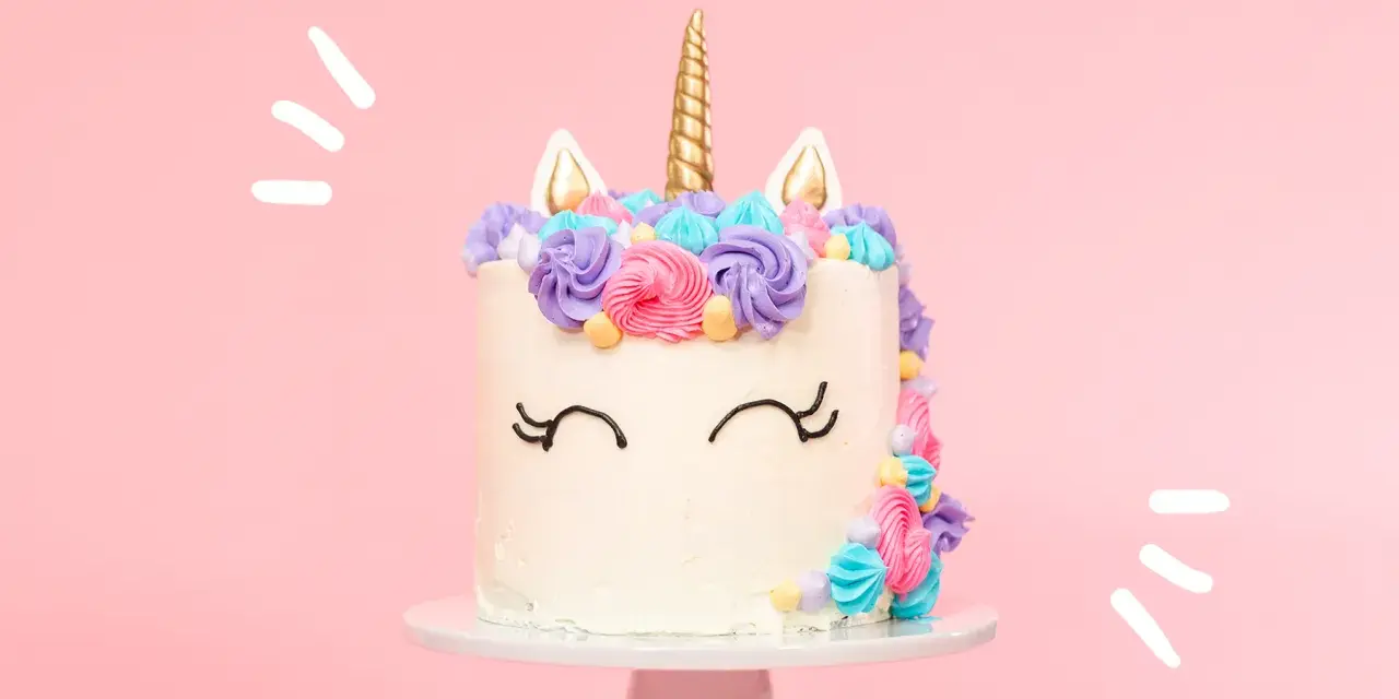 Magisk enhörningstårta med horn och öron, dekorerad med färgglad frosting. Ett perfekt unicorn tårta recept för kalaset!