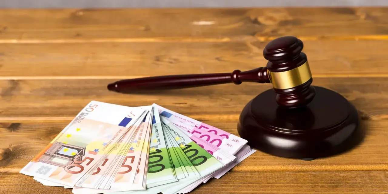 Ein Richterhammer liegt neben Euro-Scheinen. Die Frage "wie lange muss eine Rechtsschutzversicherung bestehen?" wird hier visuell thematisiert.