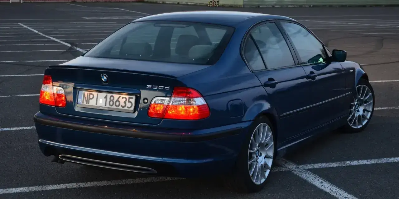Niebieskie BMW E46 330d na parkingu. Wiele osób chwali ten model za osiągi i komfort.