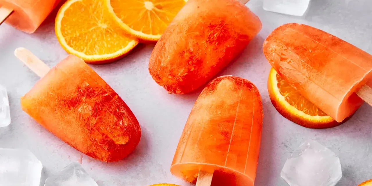 Erfrischendes Aperol Eis mit Orangenscheiben und Eiswürfeln. Perfekt für heiße Sommertage.