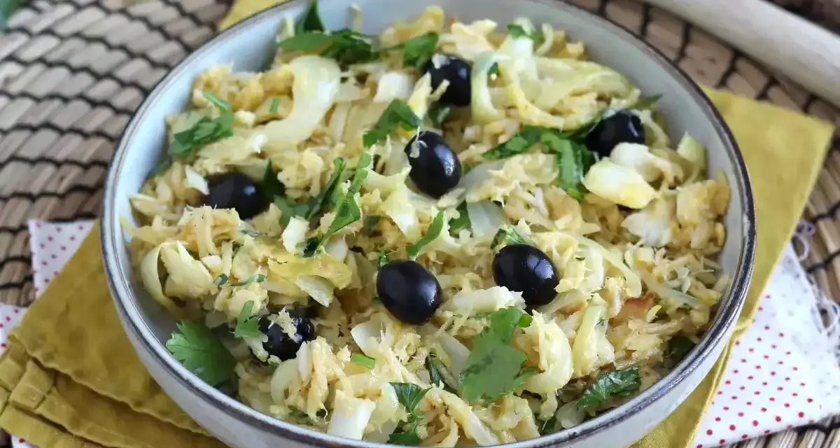 Delicioso bacalao a bras, desmenuzado con patatas finas, huevo y aceitunas negras, adornado con perejil fresco.