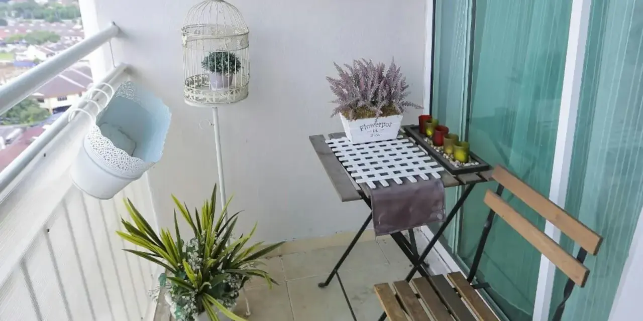 Schöne Balkon Ideen: Ein kleiner Tisch mit Stühlen, Pflanzen in Körben und eine dekorative Vogelkäfig schaffen Gemütlichkeit.