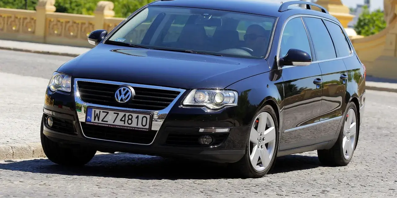 Czarny Volkswagen Passat B6 2.0 TDI 140KM na polskich tablicach rejestracyjnych WZ 74810, jadący po brukowanej drodze.