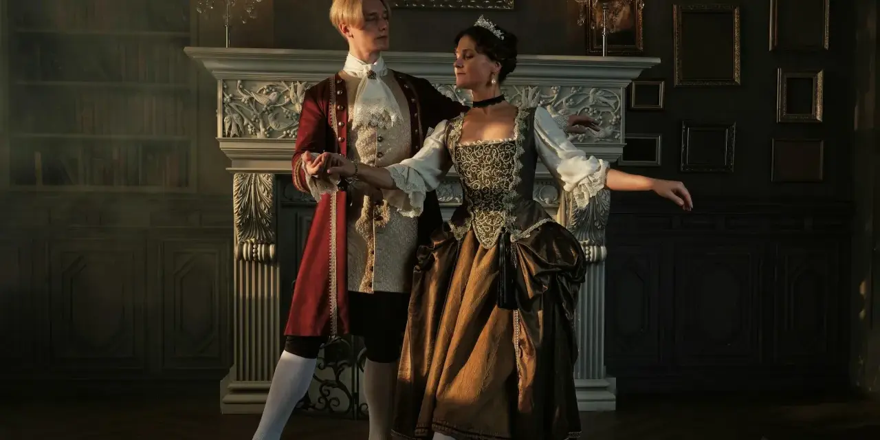 Pareja bailando en un salón elegante, como si estuvieran reviviendo la época de quien inventó el baile.
