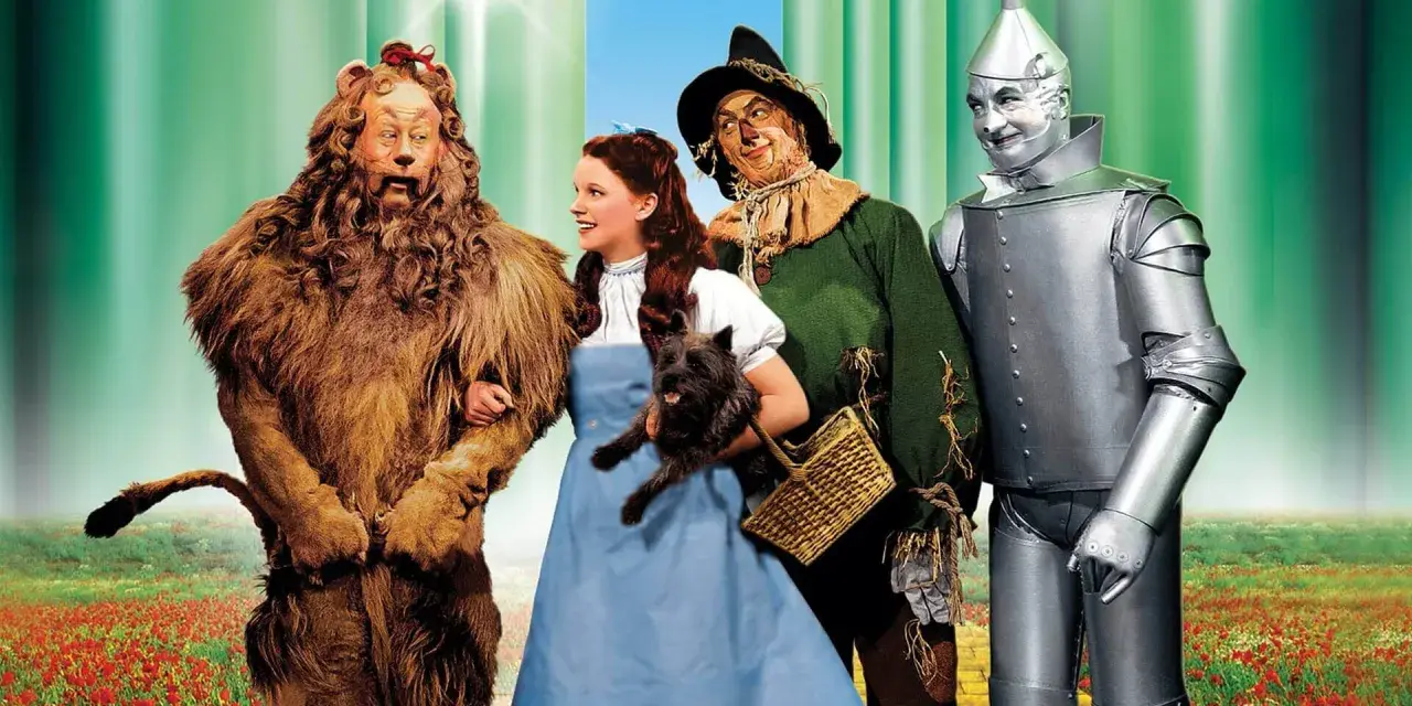 Il leone codardo, Dorothy con Toto, lo spaventapasseri e l'uomo di latta camminano sul sentiero di mattoni gialli. Il linguaggio dei colori evoca un mondo magico.