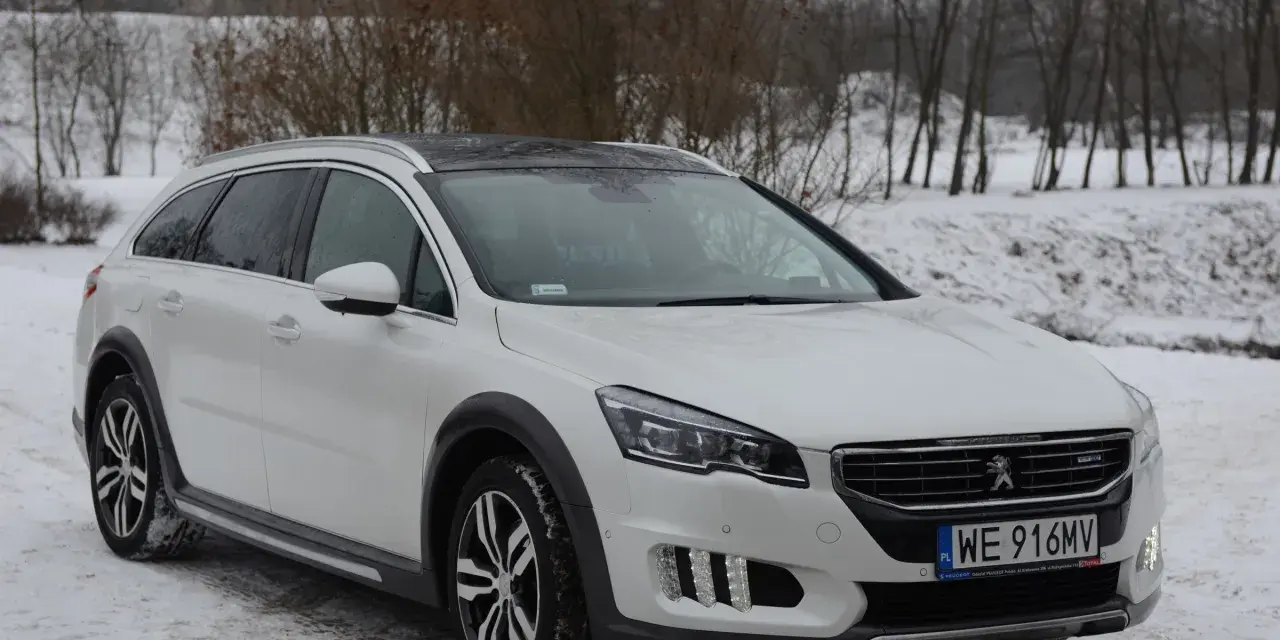 Biały Peugeot 508 RXH na śniegu, gotowy na zimowe wyzwania.