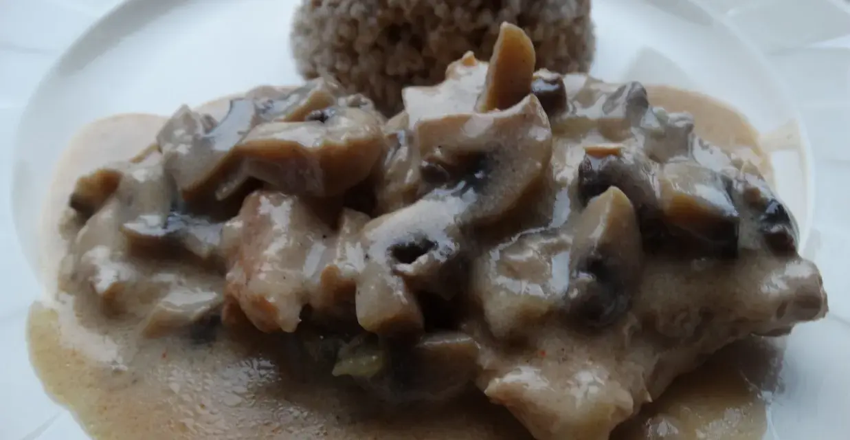 Pyszny schab duszony z pieczarkami w kremowym sosie, podany z kaszą gryczaną.