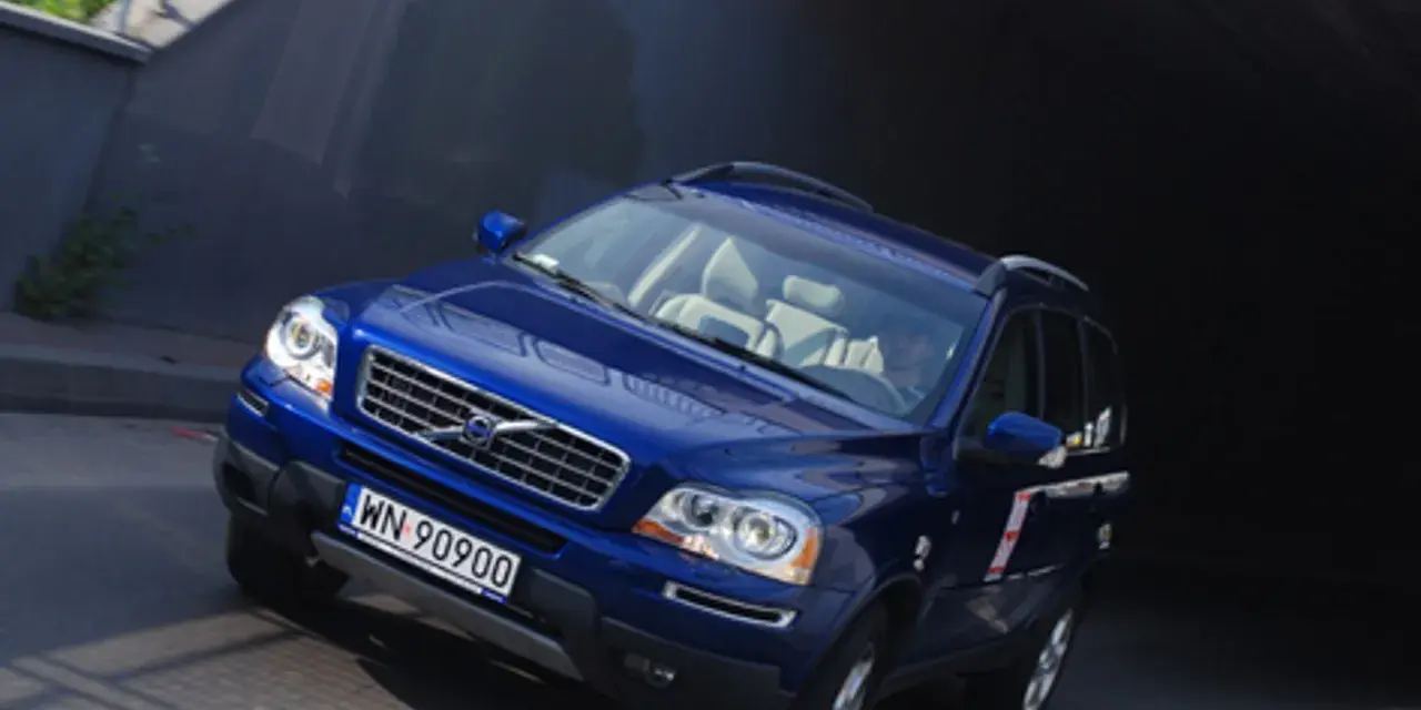 Błękitne Volvo XC90 V8 z jasnym wnętrzem wjeżdża do ciemnego tunelu.