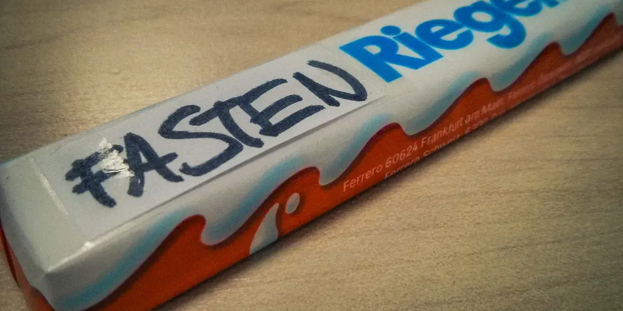 Ein Schokoriegel mit der Aufschrift "#FASTEN Riegel" – eine humorvolle Frage, was man in der Fastenzeit isst.