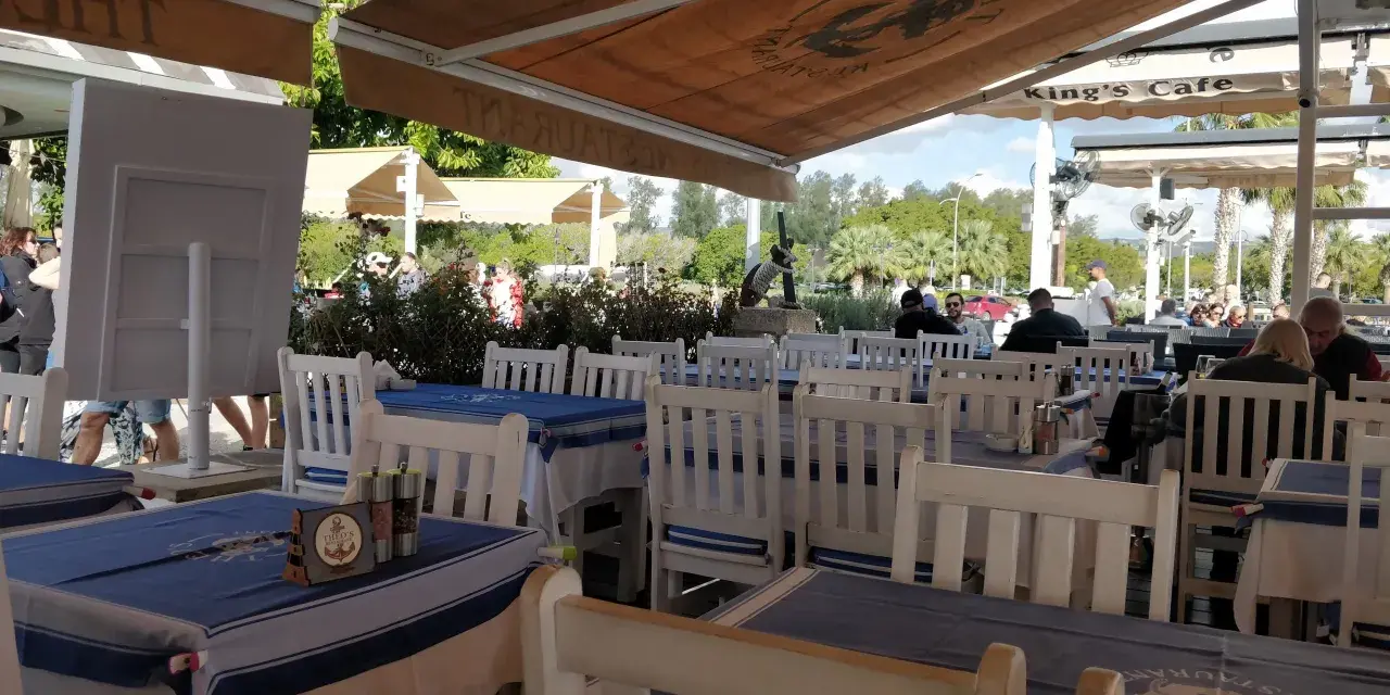 Uroczy ogródek restauracyjny w Larnace z niebiesko-białymi obrusami. Idealne miejsce, by dowiedzieć się, co i gdzie zjeść w Larnace.