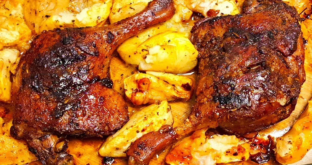 Chrupiące udka z kaczki z piekarnika, otoczone pieczonymi ziemniakami, kuszą apetycznym wyglądem i aromatem.