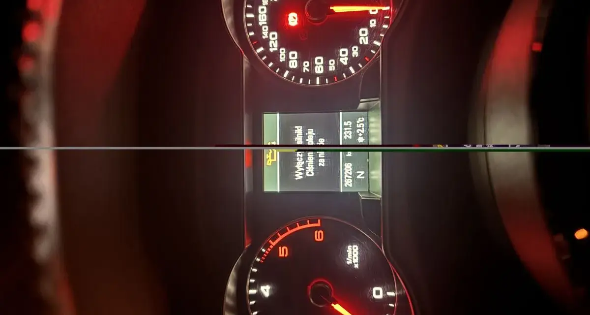 Deska rozdzielcza oldruck audi: prędkościomierz, obrotomierz i ekran komputera pokładowego.