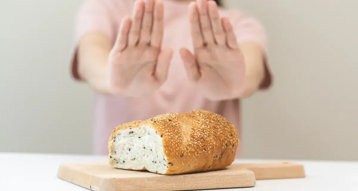 Osoba odrzuca chleb, sygnalizując uczulenie na gluten i laktozę objawy.