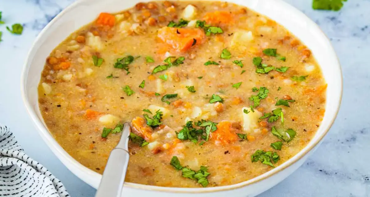 Un tazón de sopa de lentejas casera con zanahorias y patatas, perfecto para aprender como hacer lentejas.