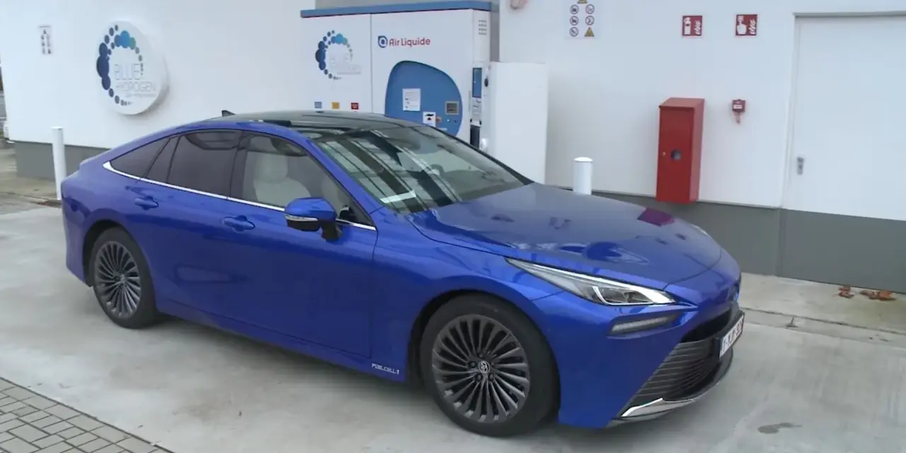 Niebieska Toyota Mirai na stacji wodorowej. Zastanawiasz się nad toyota mirai cena? To przyszłość motoryzacji.
