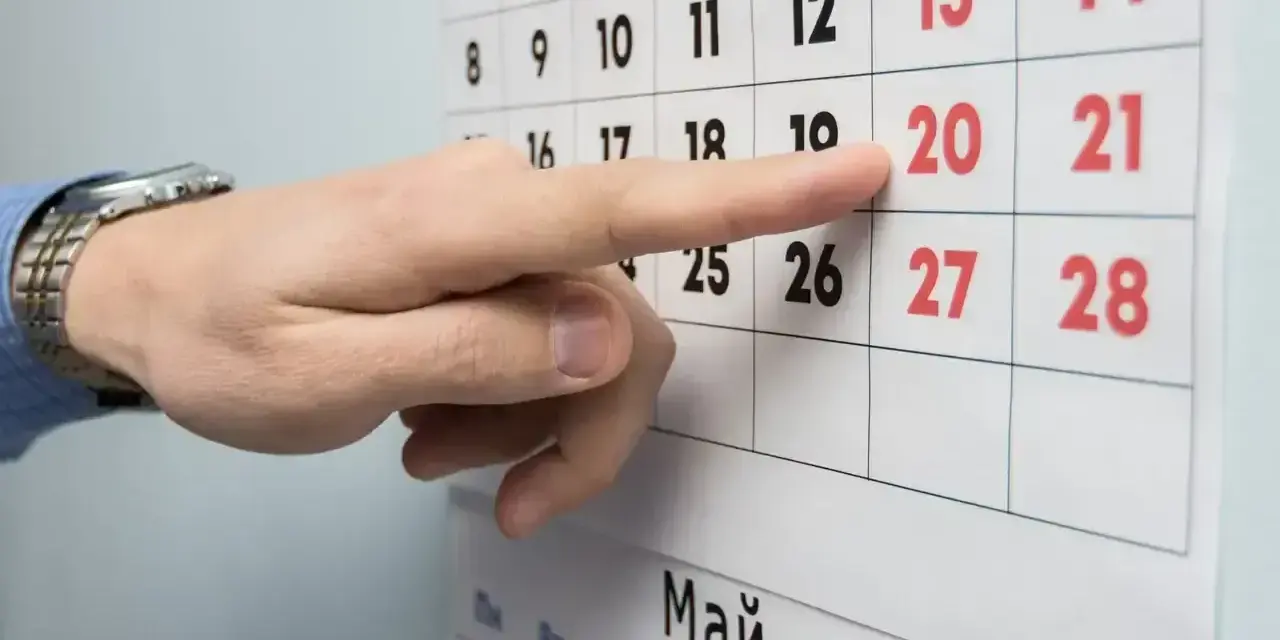 Palec wskazuje datę 20 na kalendarzu. Czas na podjęcie decyzji o okresie wypowiedzenia umowy o pracę.