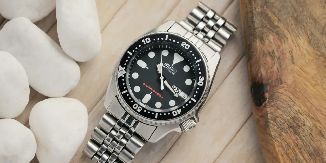 Zegarek diver z czarną tarczą i metalową bransoletą. Niezawodny mechanizm Seiko, gotowy na każdą przygodę.