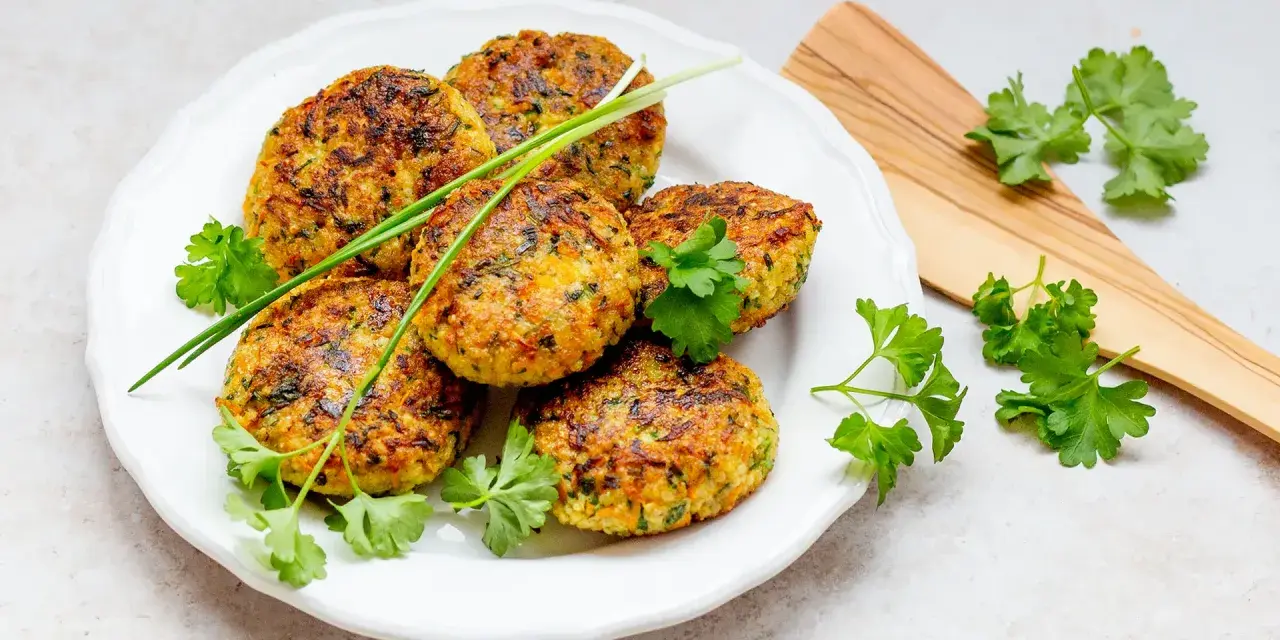 Goldbraune Hirse-Patties, garniert mit frischen Kräutern, sind ein köstliches Beispiel für Hirse Gerichte.