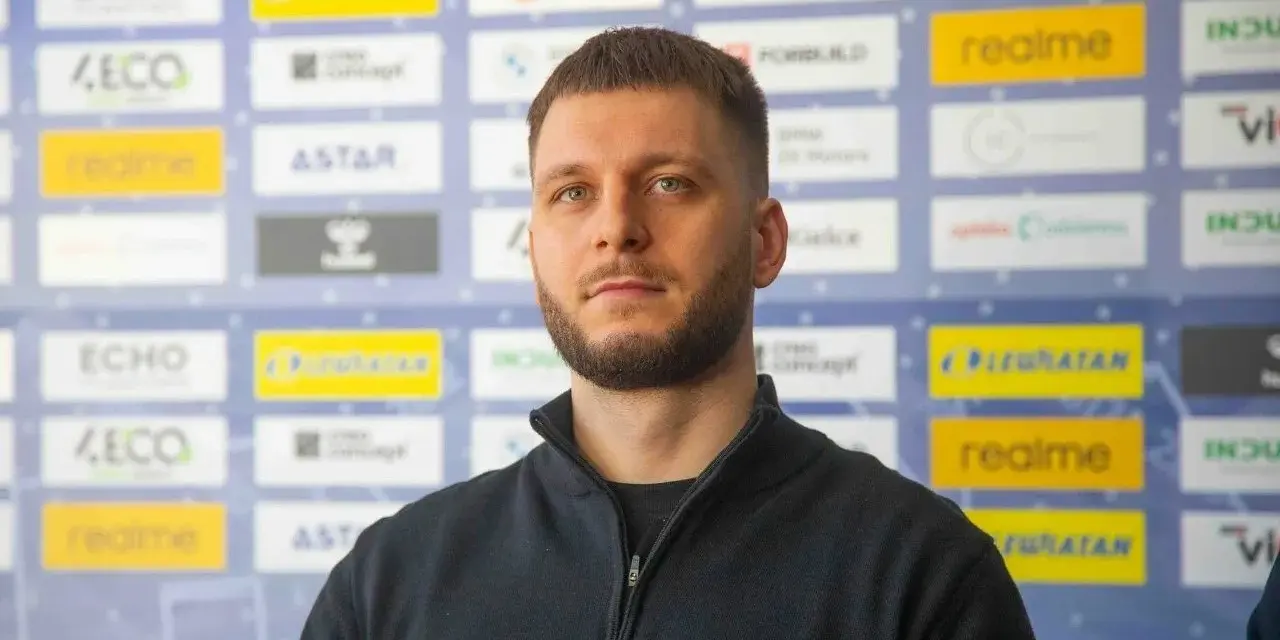 Aleks Vlah, z charakterystyczną brodą i krótką fryzurą, pozuje na tle ścianki z logotypami sponsorów, m.in. "ECHO" i "realme".
