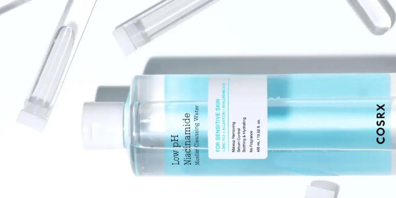 En flaska COSRX Low pH Niacinamide Micellar Cleansing Water, en mild sminkborttagning olja för känslig hud, omgiven av provrör.