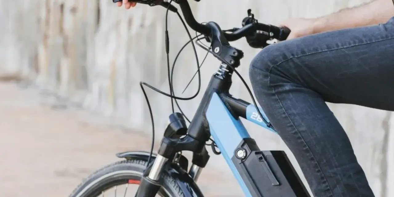 Osoba na rowerze elektrycznym, który jest pojazdem mechanicznym, jedzie po mieście.