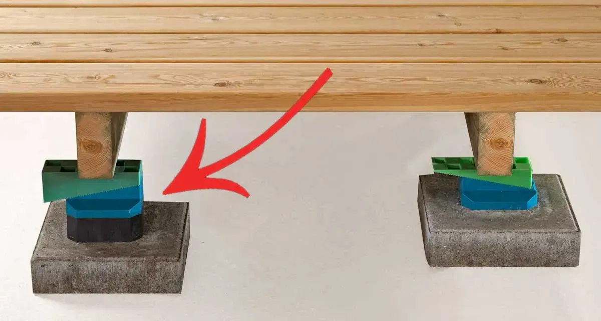 Stöd för att bygga trall: trästolpar vilar på justerbara klossar ovanpå stenplattor.