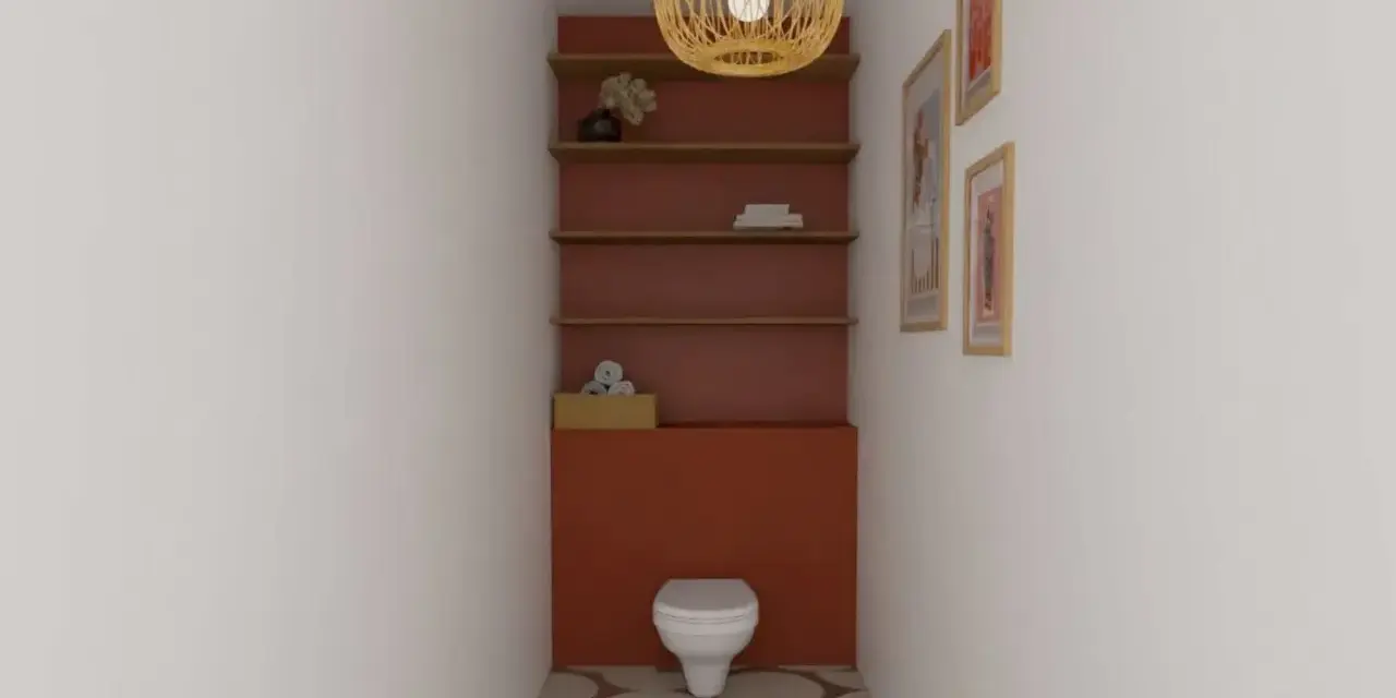 Un WC blanc est niché dans un alcôve aux murs rouge brique. Des étagères en bois flottent au-dessus, ornées d'objets décoratifs. Le sol est carrelé de cercles dans des tons terreux.