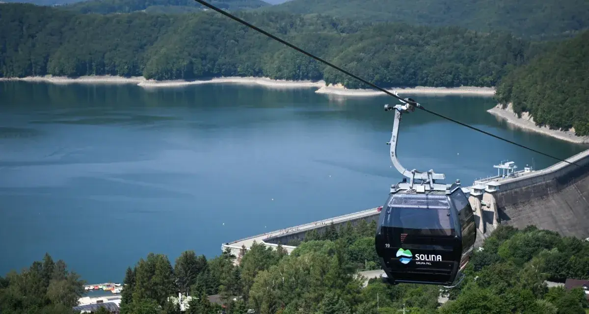 Kolejka linowa nad Soliną, idealna na podróż pociągiem w Bieszczady. Widok na zaporę i jezioro.