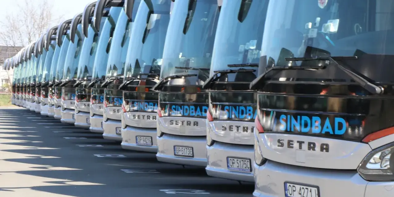 Rząd białych autokarów Sindbad Setra gotowych do podróży z Niemiec do Polski.