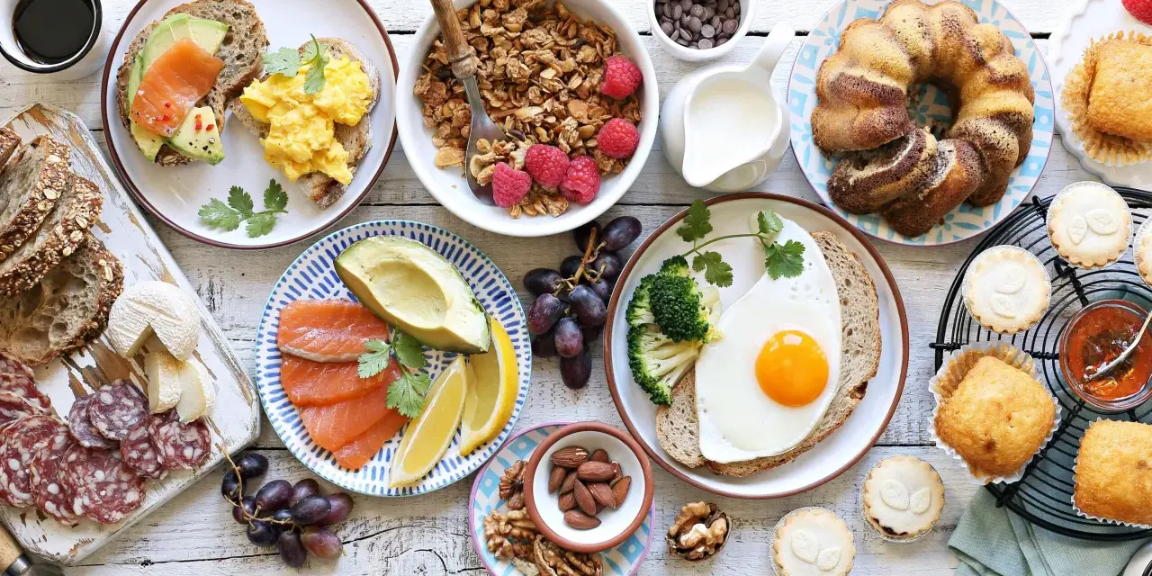 Leckeres Fingerfood für den Osterbrunch: Rührei, Lachs, Avocado, Kuchen, Muffins und Nüsse.