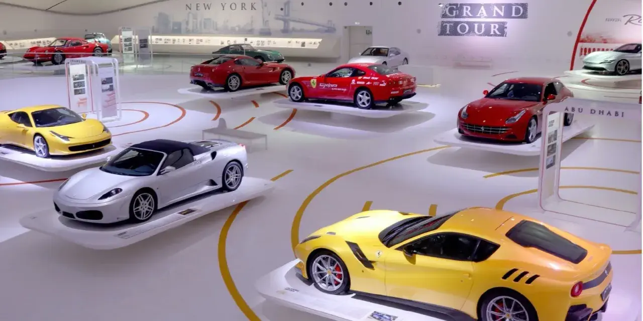 W muzeum Ferrari w Maranello lub w Modenie, na wystawie "Grand Tour", prezentowane są lśniące modele, w tym żółty i srebrny kabriolet.