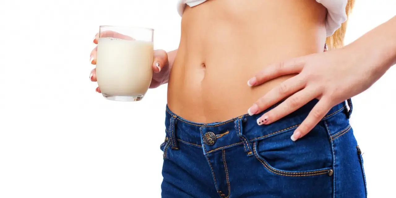 Donna con bicchiere di latte, un aiuto per sapere cosa bere la sera per andare di corpo.