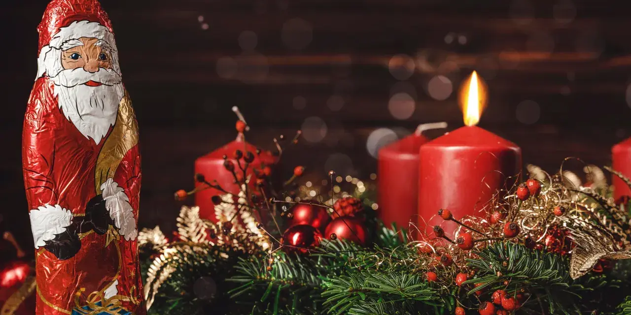 Schokoladen-Nikolaus und Adventskranz mit brennender Kerze. Der zweite Adventssonntag ist da!