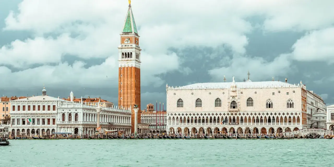 Venezia: Palazzo Ducale, Campanile e il ponte dei sospiri prigione, con gondole sull'acqua.