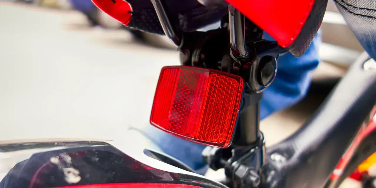 Catadiottri cosa sono? Questo è un riflettore rosso su una bicicletta, essenziale per la sicurezza.