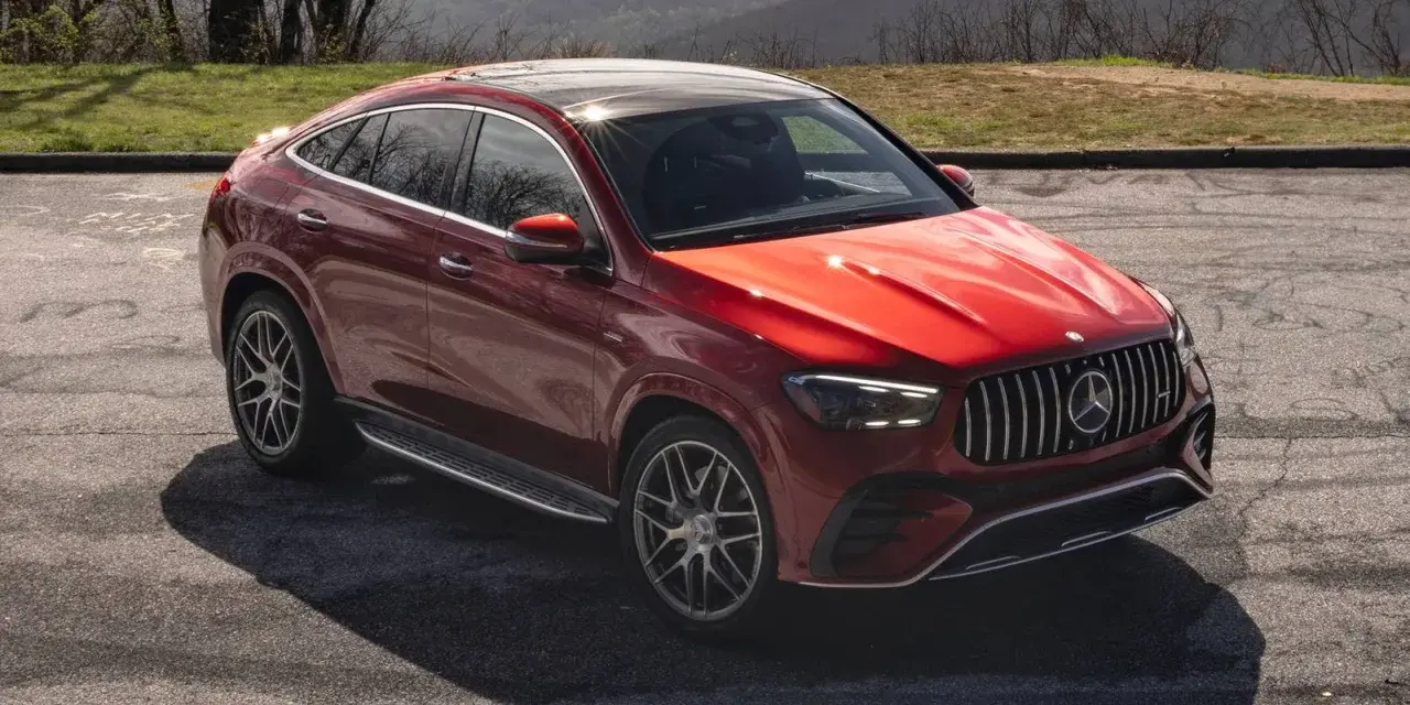 Czerwony Mercedes SUV, jeden z najnowszych mercedes suv modele, zaparkowany na tle górskiego krajobrazu.
