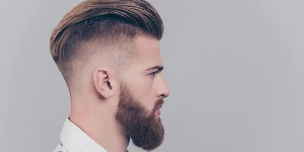 Mężczyzna z modnym irokezem i zadbaną brodą, stylizacja na rockmana.