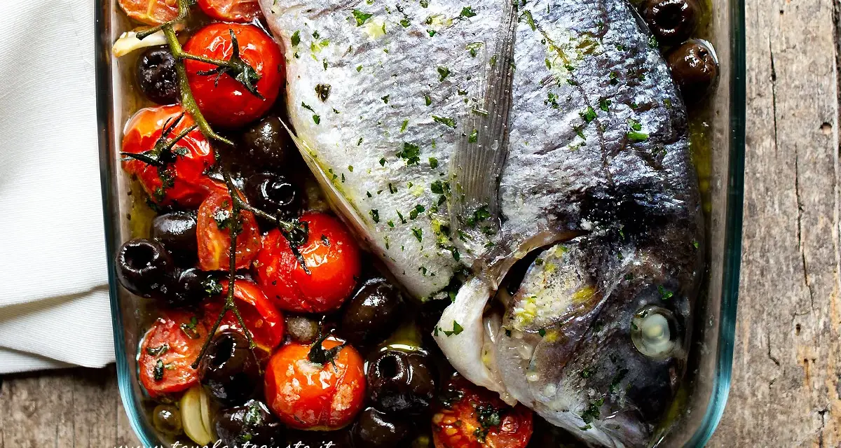 Filetti di orata al forno con pomodorini, olive nere e aglio, un piatto saporito e profumato.