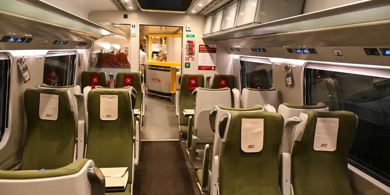 Wnętrze wagonu PKP Intercity. Puste zielone fotele czekają na pasażerów. Pamiętaj, że pkp intercity bilet bez gwarancji miejsca do siedzenia może oznaczać podróż na stojąco.