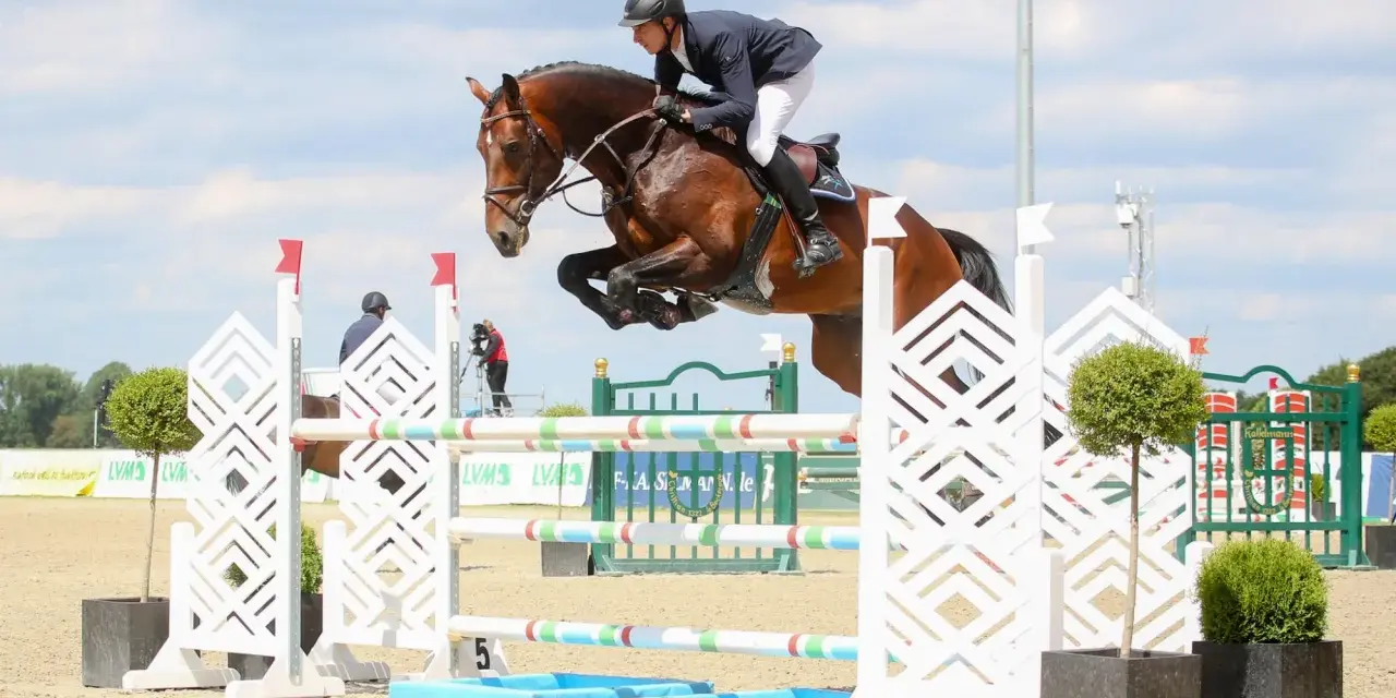 Un cavalier et son cheval, un étalon kannan, franchissent un obstacle lors d'une compétition d'équitation.