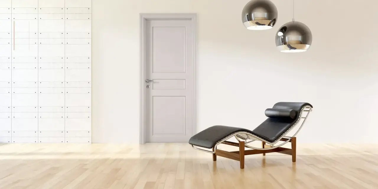 Divano in pelle nera e metallo, con un'elegante porta tortora e un muro con texture geometrica. Un perfetto abbinamento tortora e verde per un ambiente moderno.