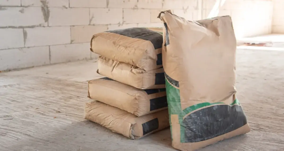 Pile de sacs de ciment sur un chantier. Pour estimer combien de sac de ciment pour 1m3, il faut connaître le dosage.