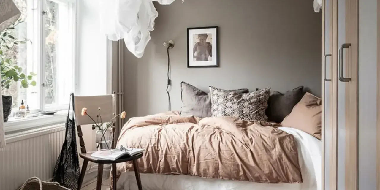 Camera da letto in **stile nordico**, con letto accogliente, tessuti naturali e un tappeto decorativo. L'ambiente evoca un **stile norvegese** rilassante.