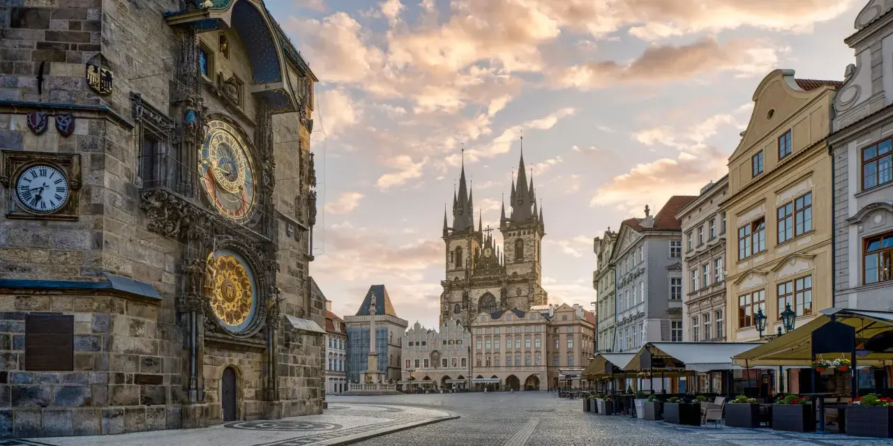 Praga co zobaczyć w jeden dzień: Ratusz Staromiejski z zegarem astronomicznym i Kościół Marii Panny przed wieżami w blasku porannego słońca.