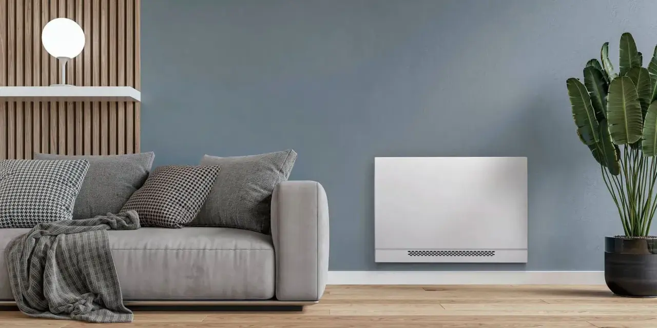 Soggiorno moderno con divano grigio e un elegante termoconvettore ad acqua al posto del termosifone, che diffonde calore in modo discreto.