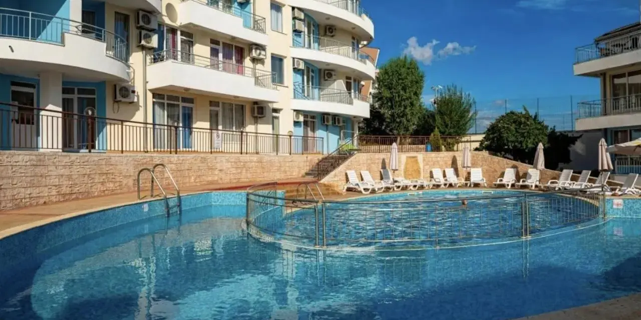Słoneczna plaża w Bułgarii: basen z leżakami i hotel w tle, idealne miejsce na wakacje.