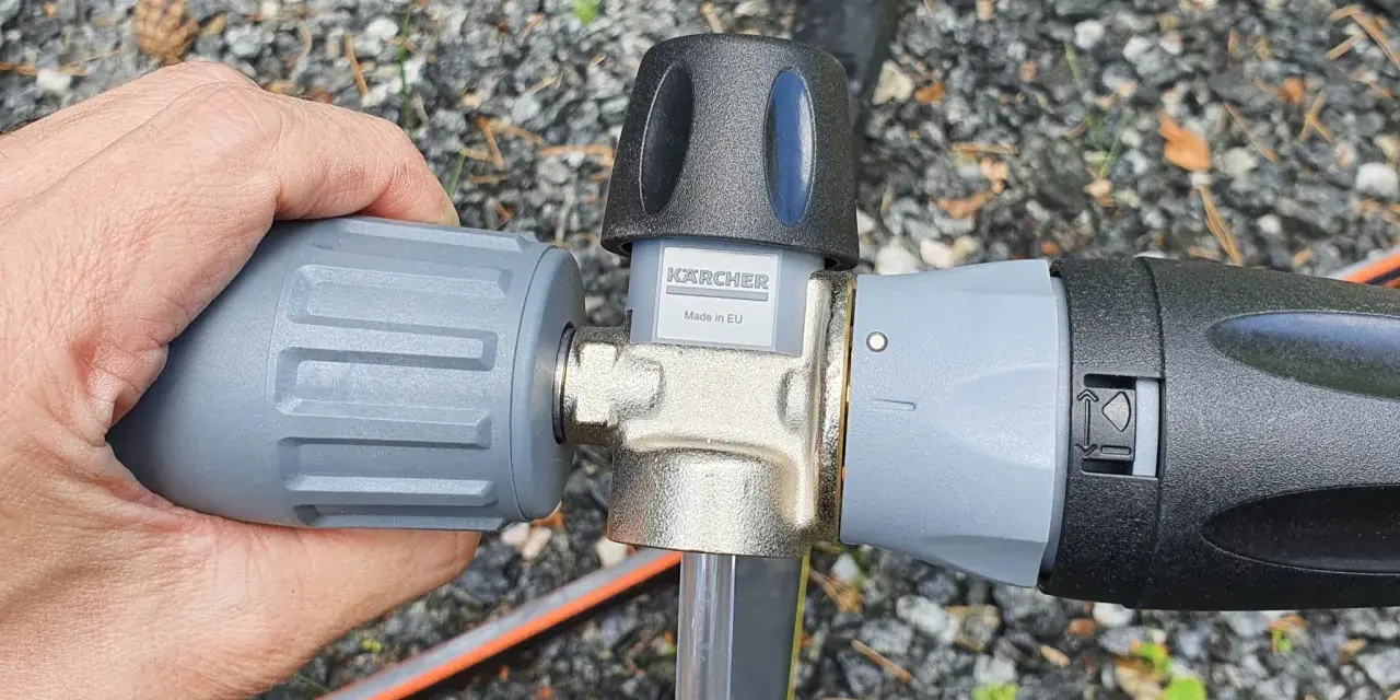 Hand connecting a Kärcher foam lance to a Kärcher K5 pressure washer.