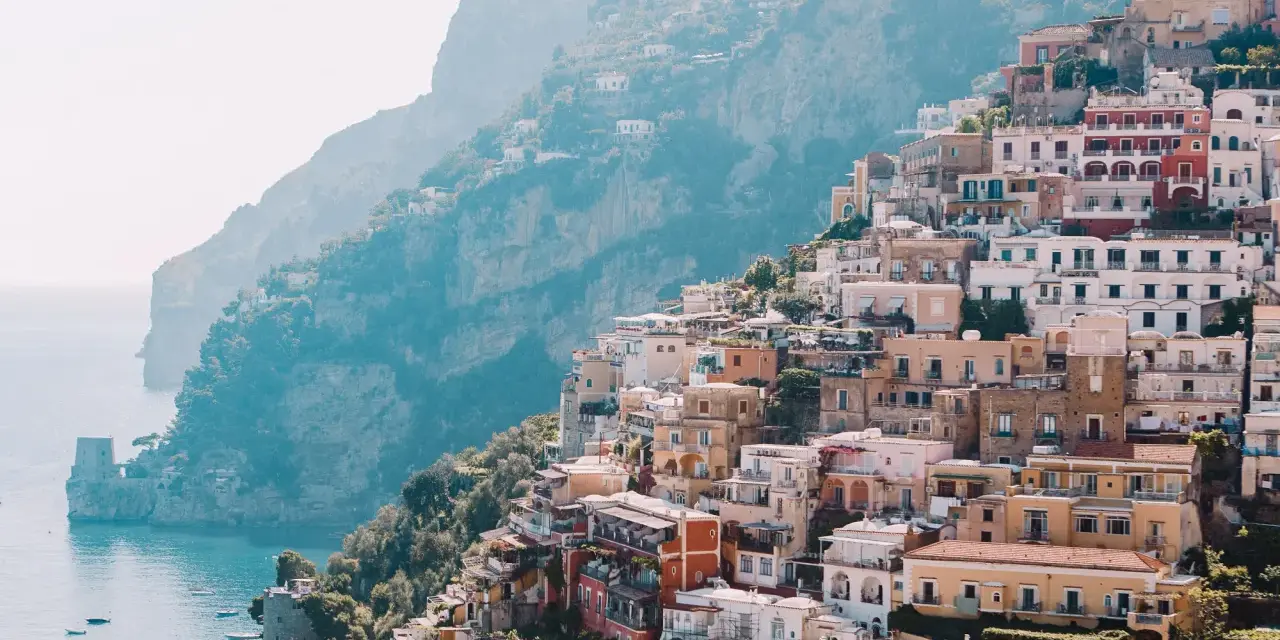 Colorful buildings cascade down a cliffside to the sea, a picturesque scene perfect for a 3 month Europe itinerary.