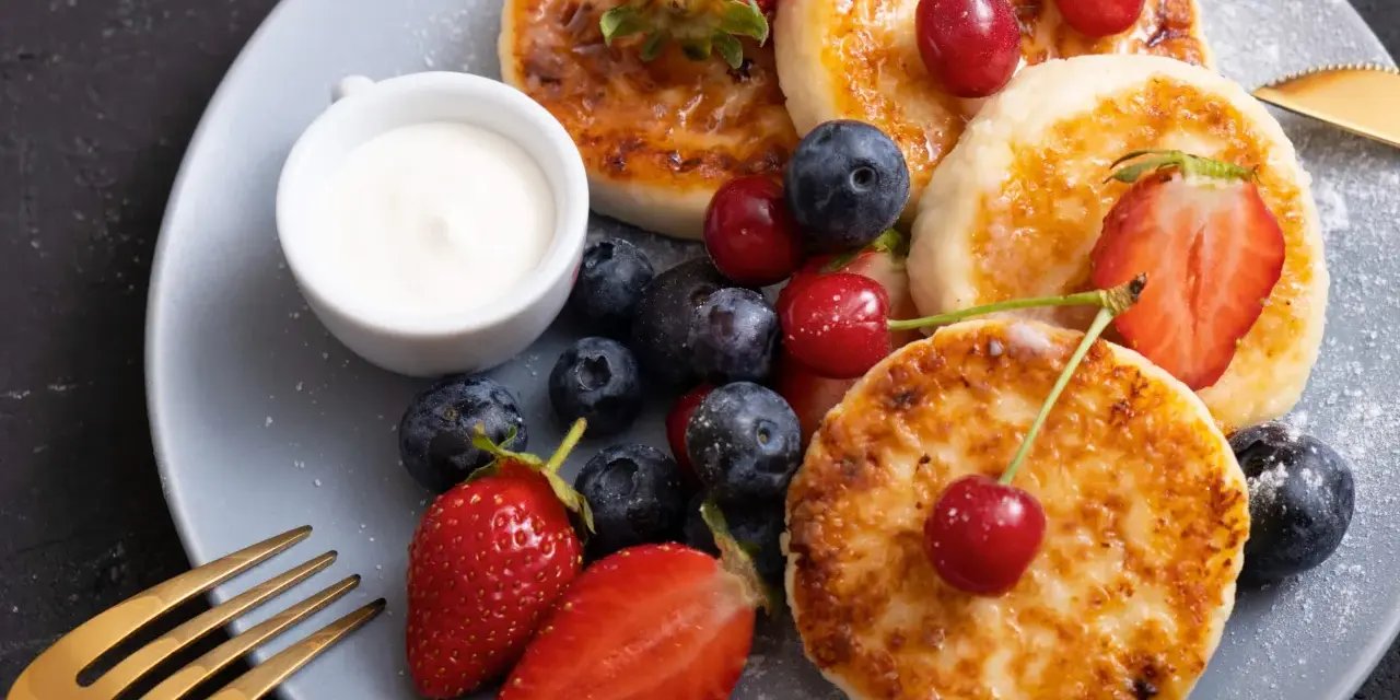 Pyszne placuszki z twarogu, idealne na śniadanie z airfryer, podane z owocami i śmietaną.