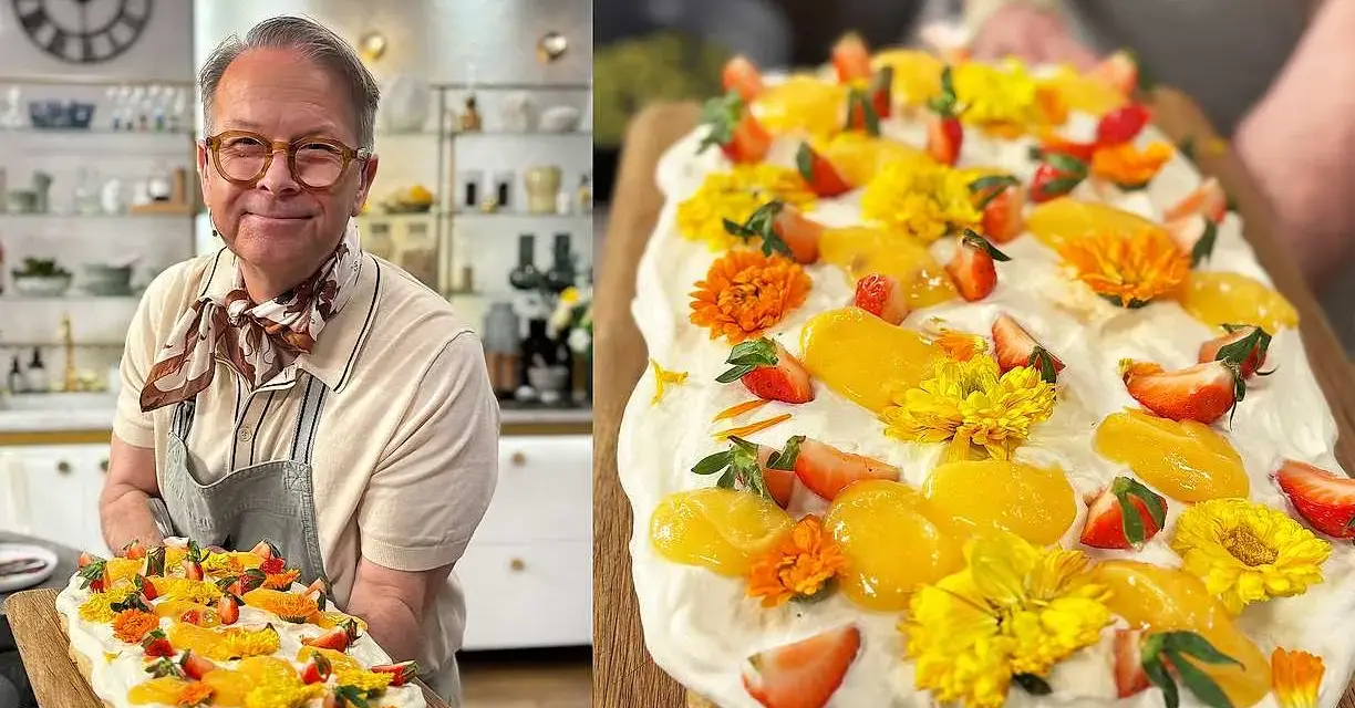 Glad kock visar upp en vacker påsktårta i långpanna, dekorerad med jordgubbar, aprikoser och gula blommor.